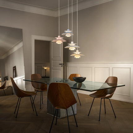 Suspensions PH 5 Opal en plusieurs coloris au-dessus d’une table
