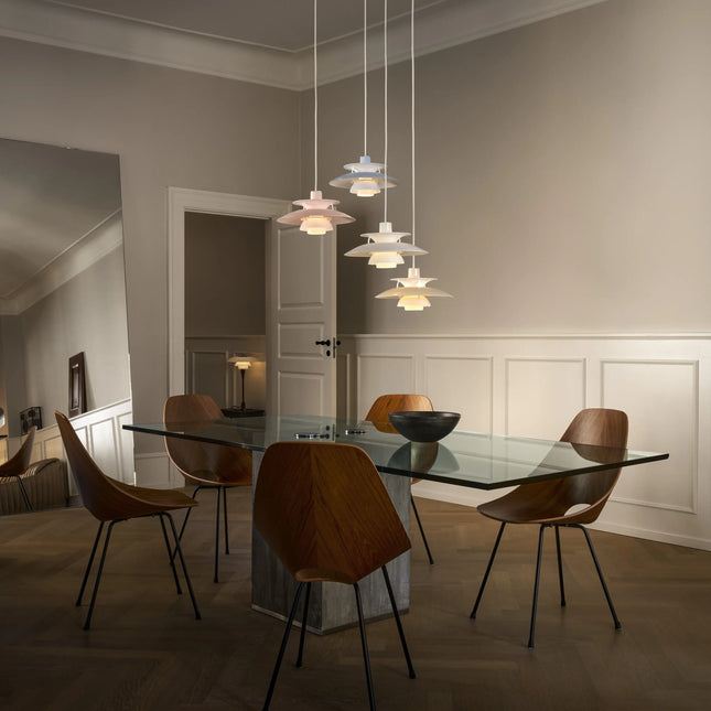 Suspensions PH 5 Opal en plusieurs coloris au-dessus d’une table