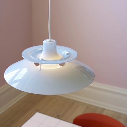 PH 5 Ø320 Opal bleu pâle au-dessus d’une table, mur rose