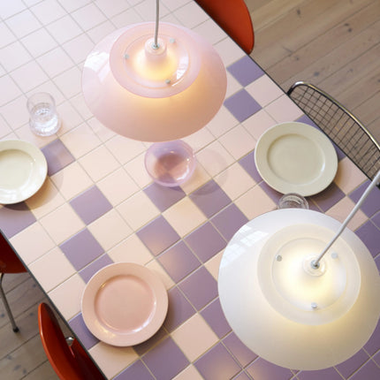 PH 5 Ø320 Opal blanc et rose pâle au-dessus d’une table carrelée