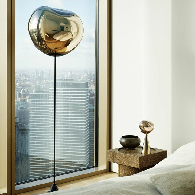 Lampadaire Melt Slim Cone bronze de Tom Dixon devant une baie vitrée